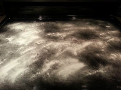 Baking soda sprinkled on a glass stove top to clean it