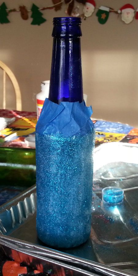 Glitter freshly applied to a glass beer bottle to be turned into a vase