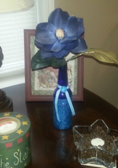 beer or soda glass bottle repurposed as a glittered vase