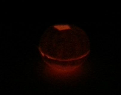 lit clementine candle glowing in the dark